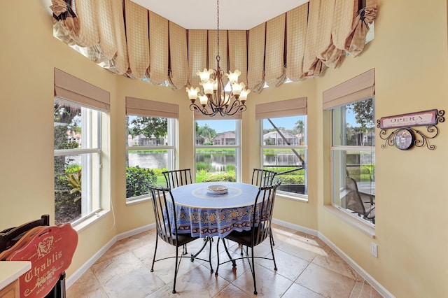 dining space featuring a water view and a notable chandelier