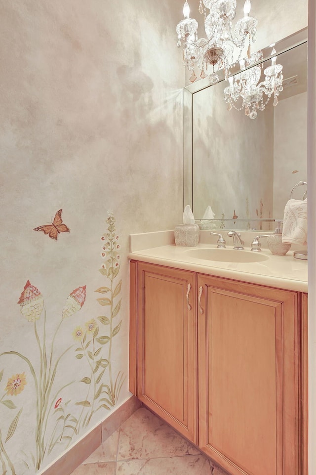 bathroom with an inviting chandelier, vanity, and tile patterned floors