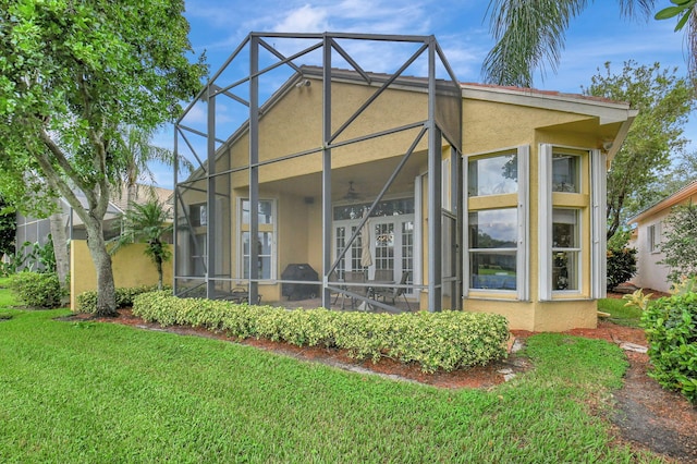 back of property with a lanai and a yard