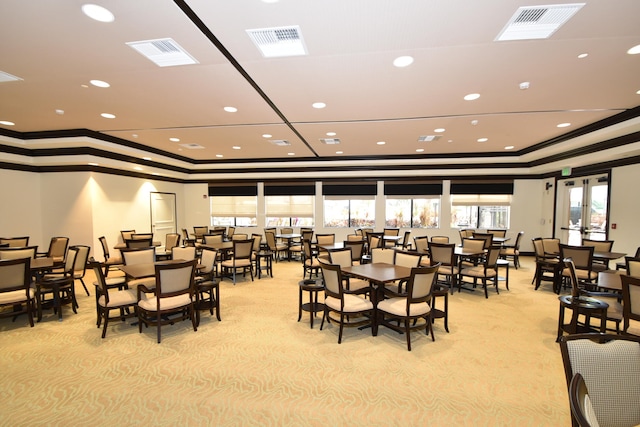 carpeted dining room with ornamental molding and a tray ceiling