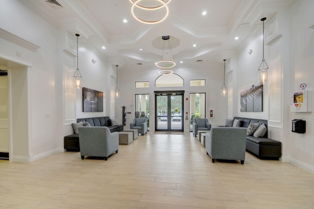 living room featuring beamed ceiling, coffered ceiling, light hardwood / wood-style flooring, a towering ceiling, and ornamental molding