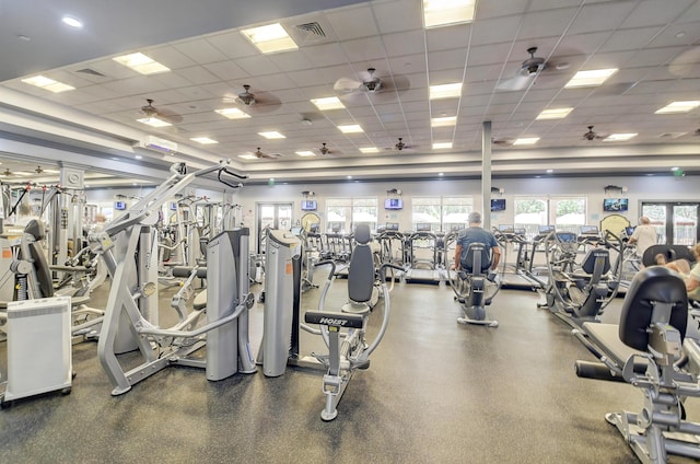 exercise room with a drop ceiling and ceiling fan