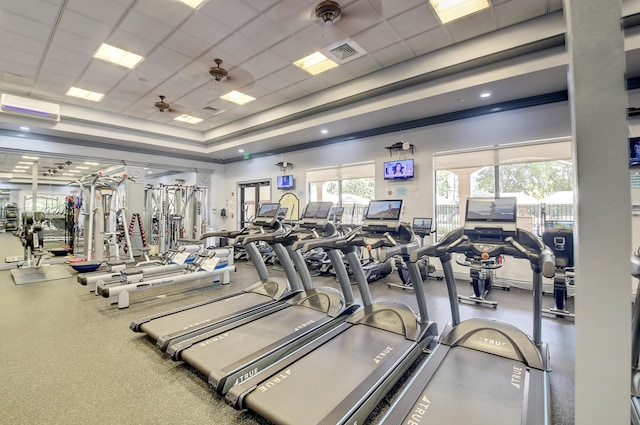 exercise room featuring ceiling fan, a raised ceiling, a paneled ceiling, and ornamental molding