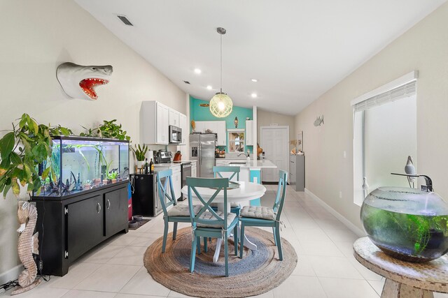 dining room with sink, lofted ceiling, and light tile patterned floors