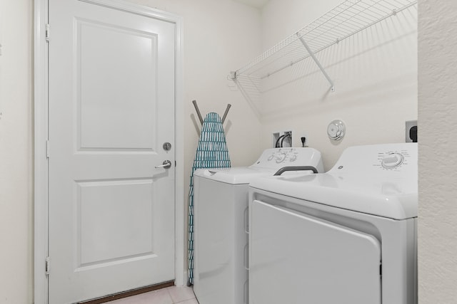 laundry area featuring light tile patterned flooring and washing machine and clothes dryer