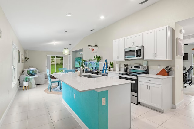 kitchen featuring appliances with stainless steel finishes, vaulted ceiling, an island with sink, pendant lighting, and sink