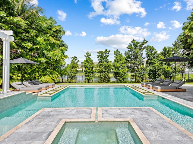 view of swimming pool featuring a patio area and an in ground hot tub