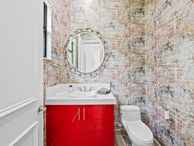 bathroom featuring toilet, hardwood / wood-style flooring, and vanity