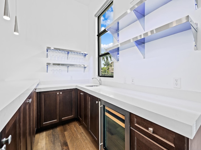 bar with wine cooler, sink, pendant lighting, and dark hardwood / wood-style floors