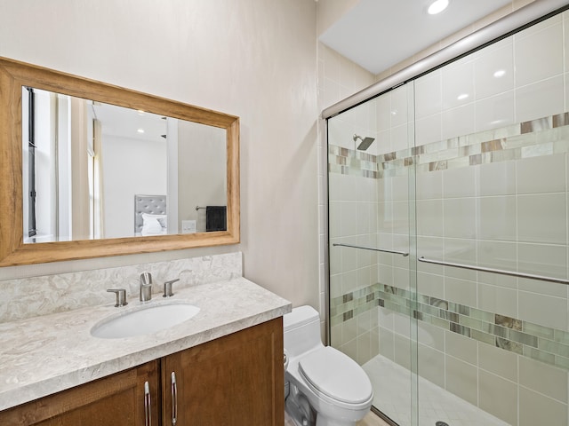 bathroom featuring vanity, toilet, and an enclosed shower