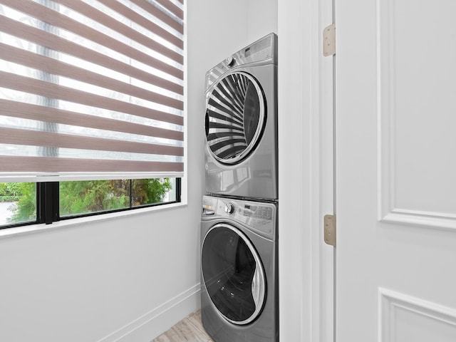 clothes washing area with stacked washer and dryer and light hardwood / wood-style flooring