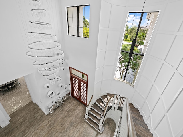 foyer entrance with a notable chandelier, dark wood-type flooring, and a wealth of natural light