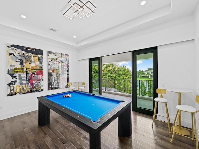 game room with a tray ceiling, dark hardwood / wood-style floors, and billiards