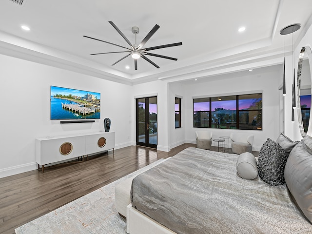 bedroom featuring hardwood / wood-style floors, a raised ceiling, access to outside, and ceiling fan