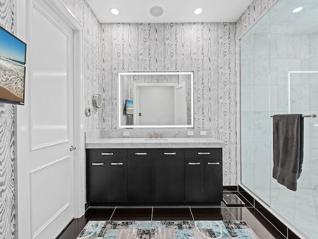 bathroom featuring a shower with door, vanity, and tile patterned floors