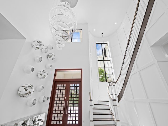 foyer entrance with french doors and a towering ceiling