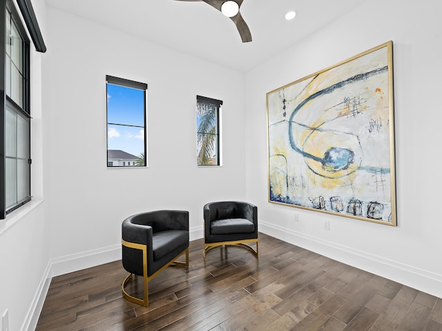 living area with ceiling fan and dark hardwood / wood-style flooring