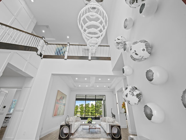 living room with hardwood / wood-style flooring and a towering ceiling