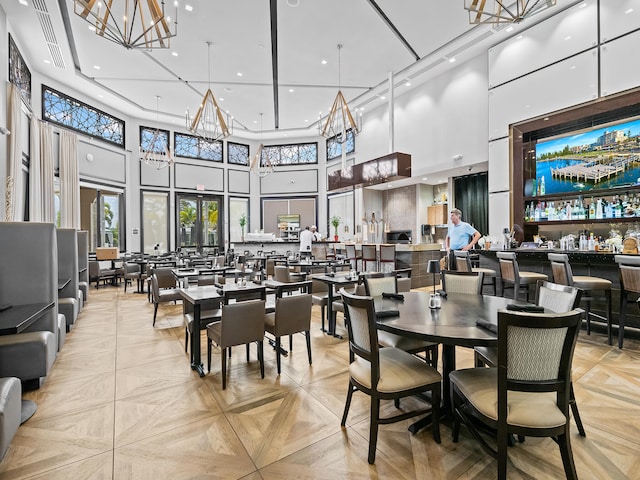 dining space with light parquet flooring and a towering ceiling