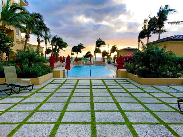 pool at dusk featuring a patio area