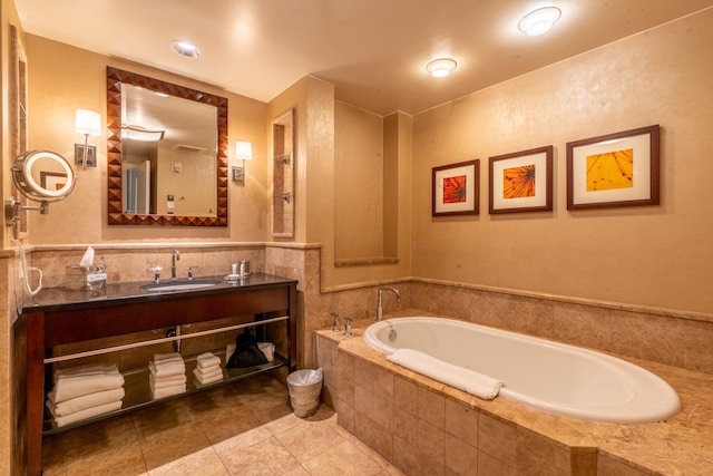 bathroom featuring tiled tub, vanity, and tile patterned floors