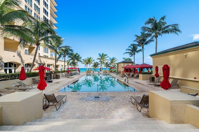 view of swimming pool featuring a patio and a water view