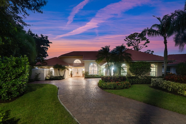 mediterranean / spanish home featuring a yard