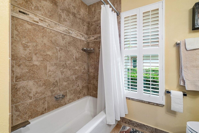 bathroom featuring shower / bath combination with curtain and toilet