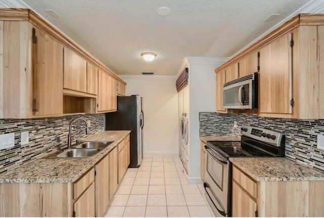 kitchen featuring crown molding, appliances with stainless steel finishes, sink, light tile patterned floors, and light stone counters