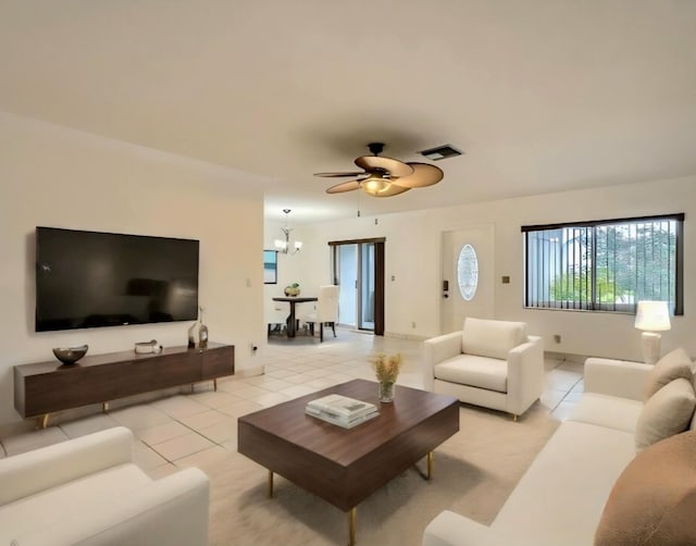 living room with ceiling fan with notable chandelier and light tile patterned floors