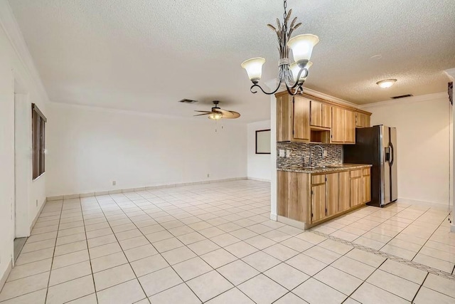 kitchen featuring stainless steel refrigerator with ice dispenser, decorative light fixtures, tasteful backsplash, light tile patterned floors, and ceiling fan with notable chandelier