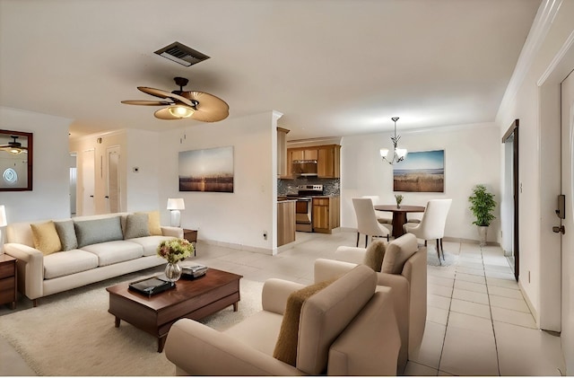 living room with ceiling fan with notable chandelier, light tile patterned floors, and ornamental molding