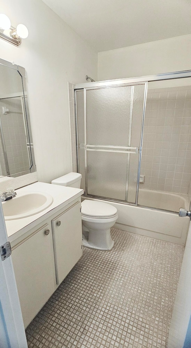 full bathroom with vanity, toilet, and bath / shower combo with glass door