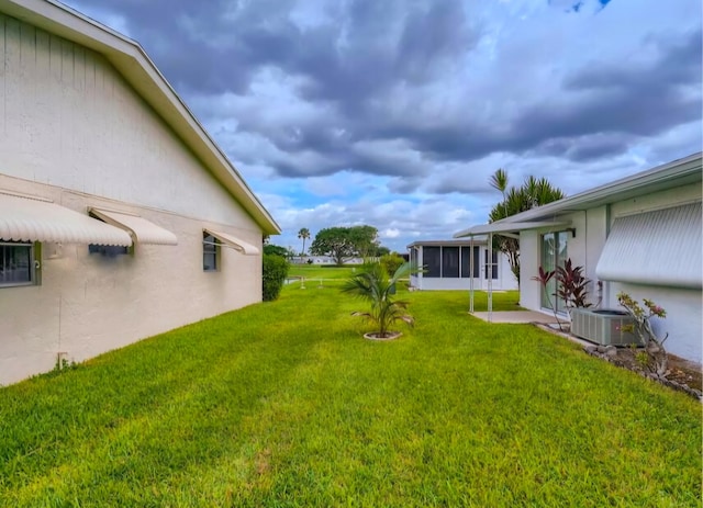 view of yard with a sunroom and central AC