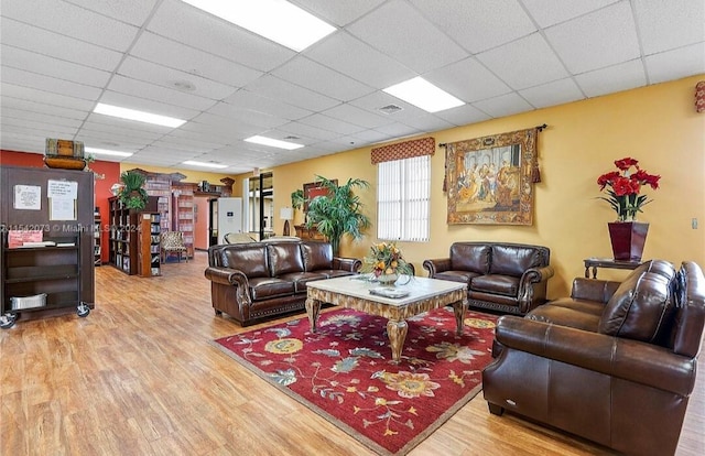 living room with a paneled ceiling and hardwood / wood-style floors