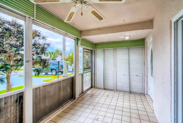 unfurnished sunroom featuring ceiling fan