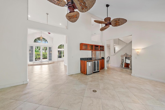 unfurnished living room featuring high vaulted ceiling, beverage cooler, ceiling fan, and light tile patterned floors