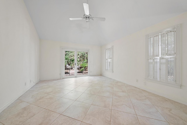 spare room with ceiling fan, lofted ceiling, and light tile patterned floors