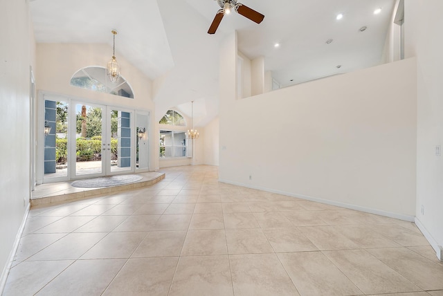 interior space featuring high vaulted ceiling, light tile patterned floors, ceiling fan with notable chandelier, and french doors