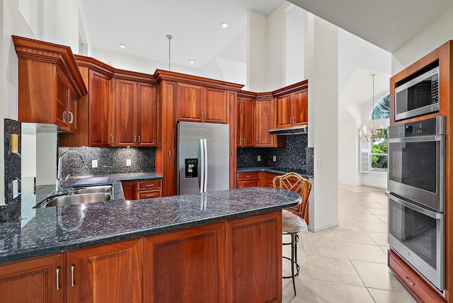 kitchen with backsplash, kitchen peninsula, appliances with stainless steel finishes, and sink