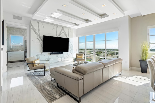 living room with a healthy amount of sunlight, a tray ceiling, and tile walls