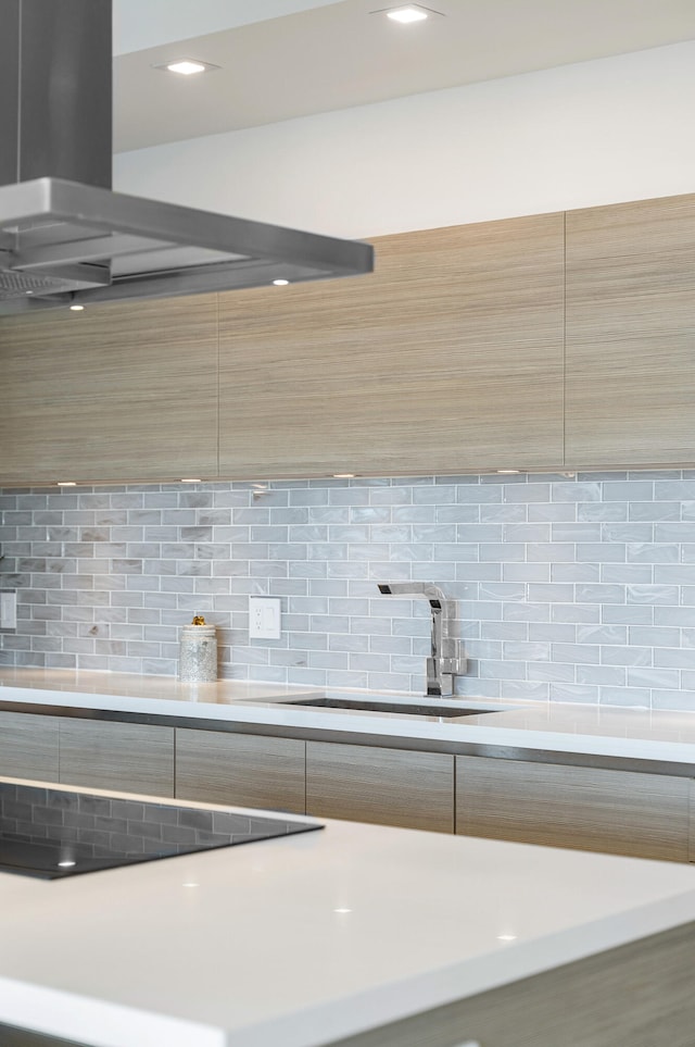 kitchen featuring black electric stovetop, decorative backsplash, sink, and extractor fan