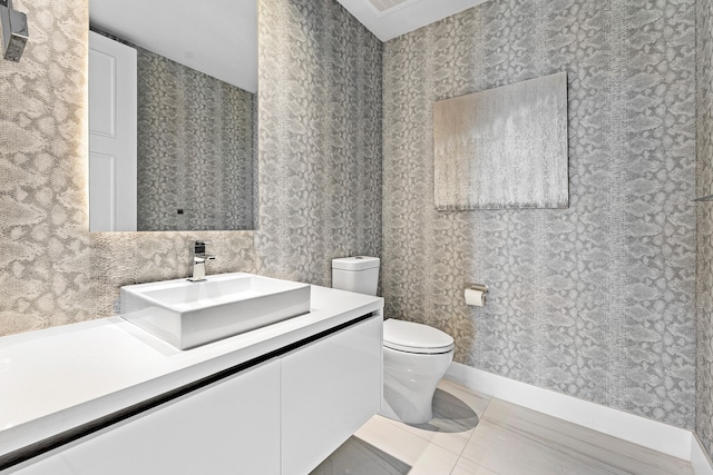 bathroom with vanity, tile patterned flooring, and toilet