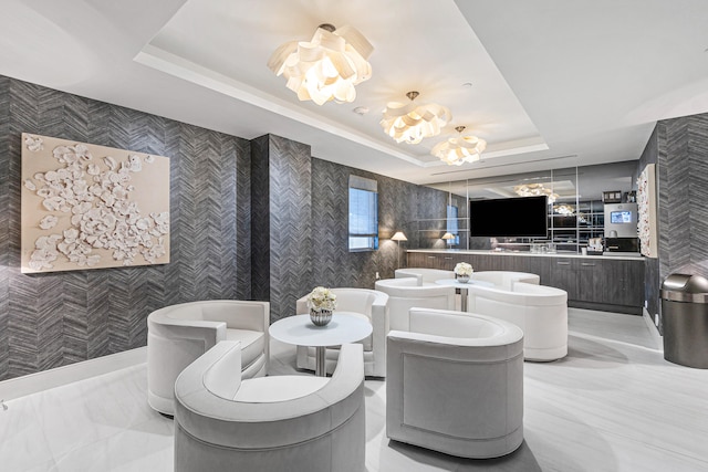 interior space with a notable chandelier, a raised ceiling, and vanity