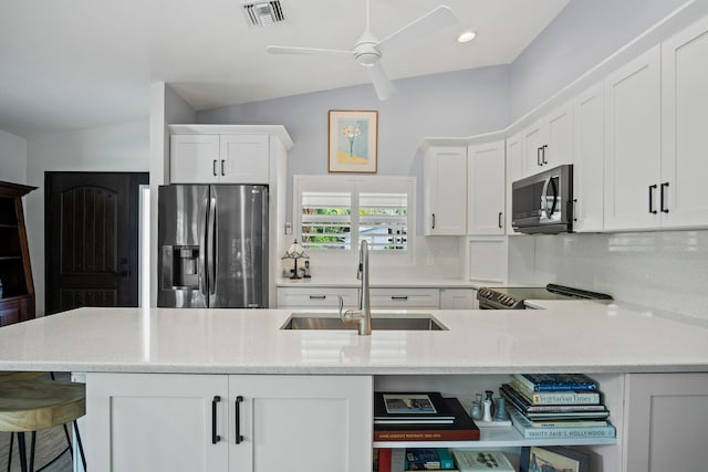 kitchen featuring sink, white cabinets, lofted ceiling, appliances with stainless steel finishes, and ceiling fan