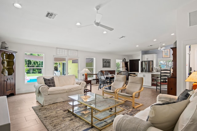 living room with ceiling fan and light wood-type flooring