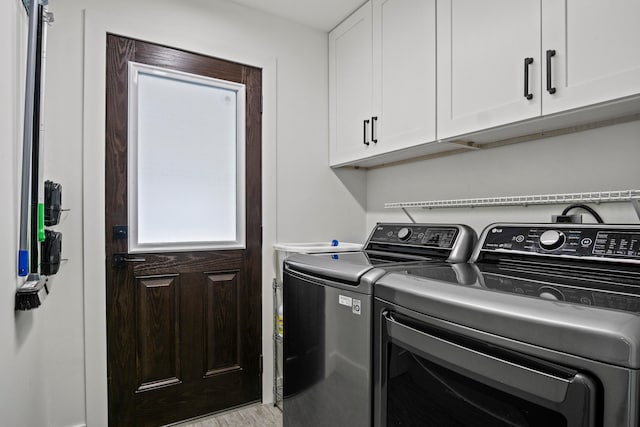 laundry area featuring separate washer and dryer and cabinets