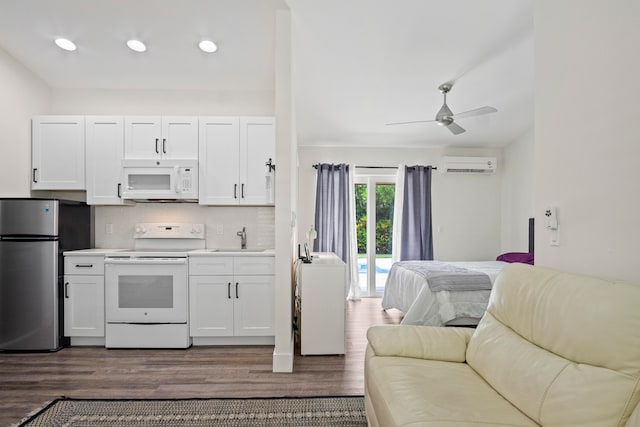 kitchen with white appliances, dark hardwood / wood-style flooring, ceiling fan, and white cabinets