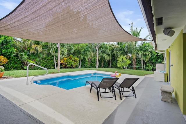 view of pool featuring a lawn and a patio