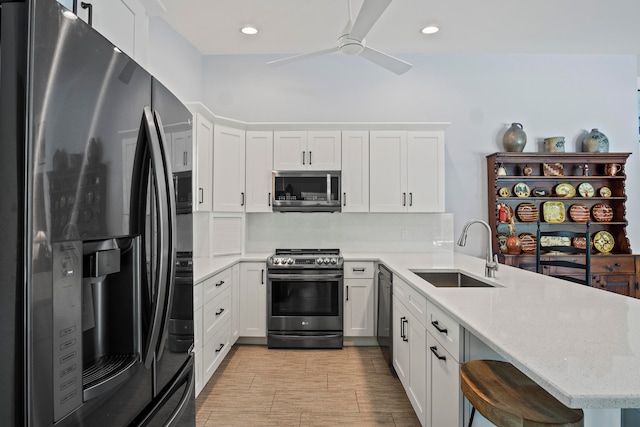 kitchen featuring kitchen peninsula, white cabinetry, sink, and stainless steel appliances